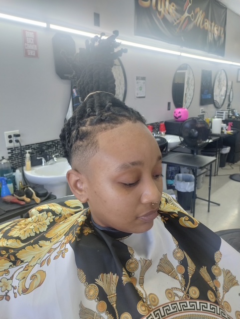High-bun locs with bald skin fade and crisp lineup